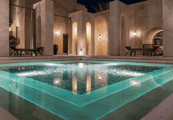 A hotel spa pool with turquoise water and stone columns