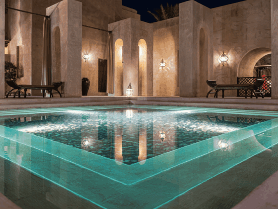 A hotel spa pool with turquoise water and stone columns