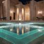 A hotel spa pool with turquoise water and stone columns