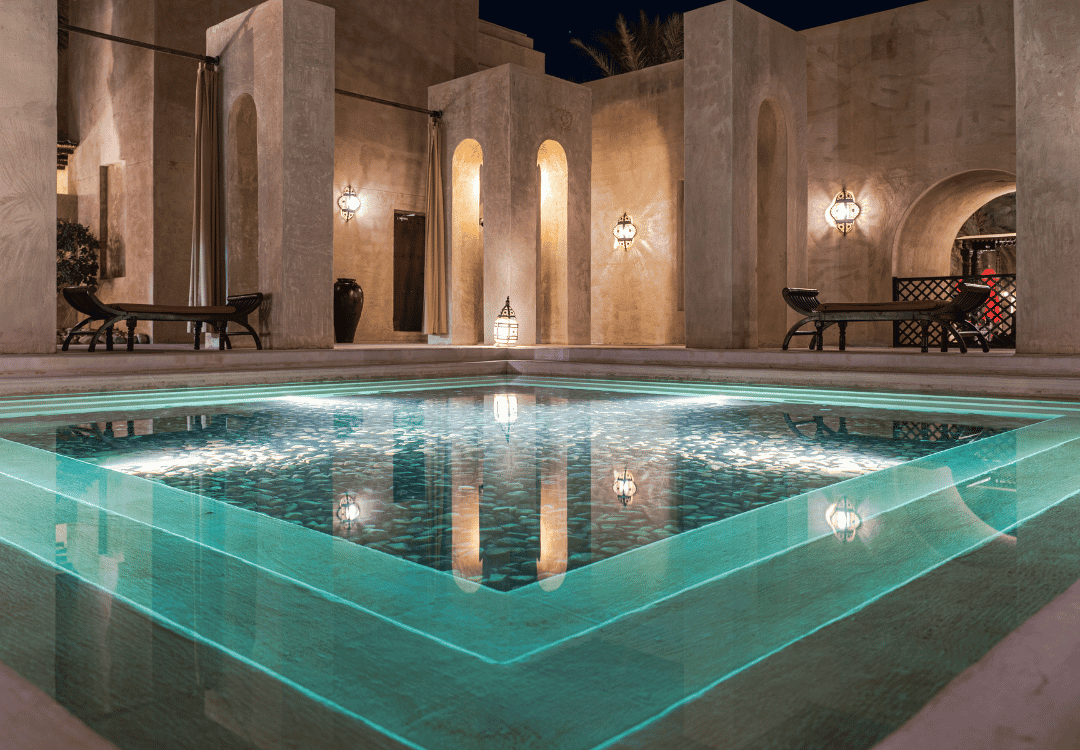 A hotel spa pool with turquoise water and stone columns